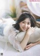 A woman laying on top of a bed with a pillow.