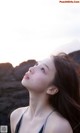 A woman with long brown hair looking up at the sky.