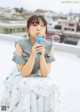 A woman sitting on top of a roof blowing bubbles.